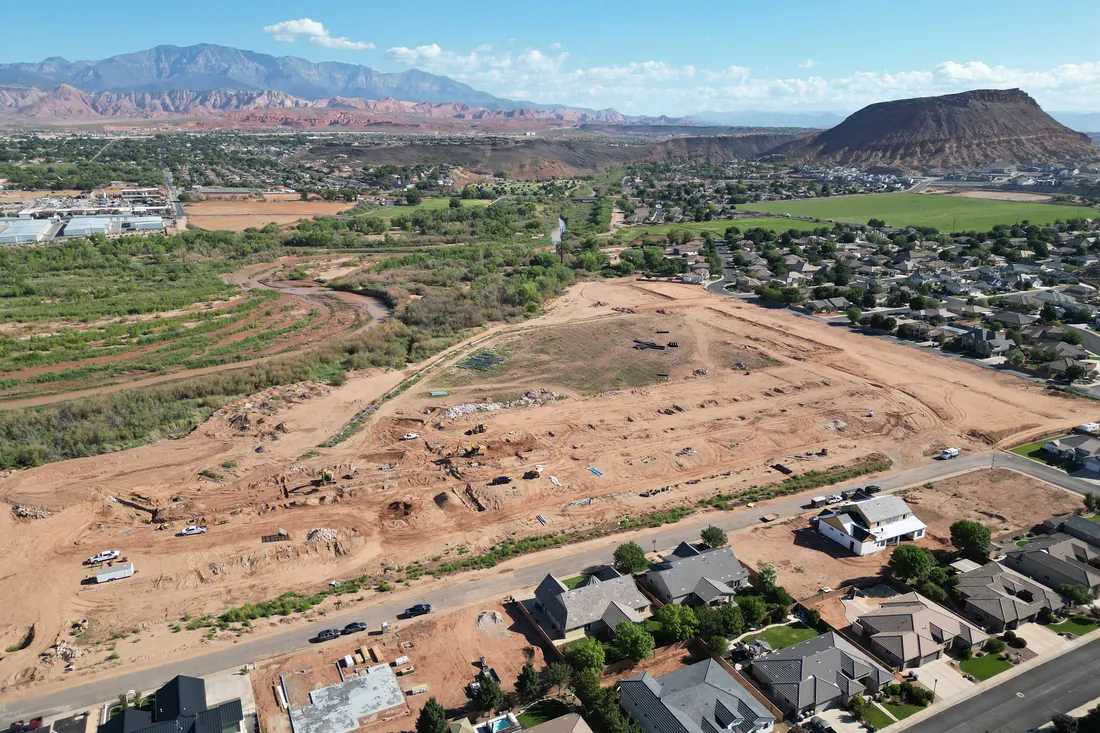 Red cliffs and a mesa rising beyond the Stillwater homesites